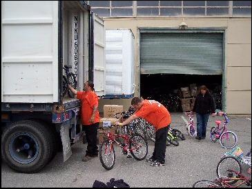 Volunteers load bicycles into a truck.